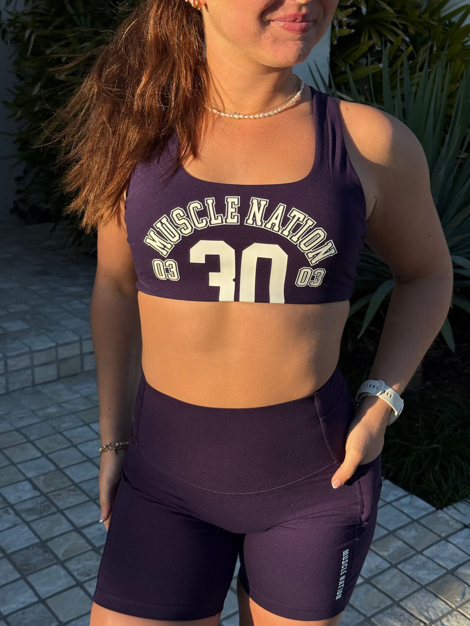 @laylahlifts wearing Unrivalled Everyday Pocket Bike Shorts in Dark Thistle and Takeover Bra in Dark Purple