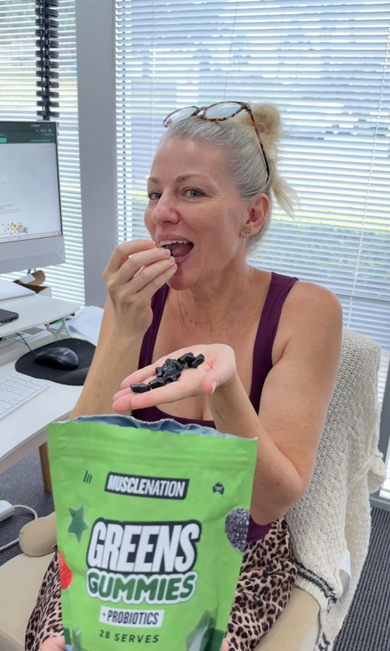 A Muscle Nation team member eating Greens Gummies at her desk