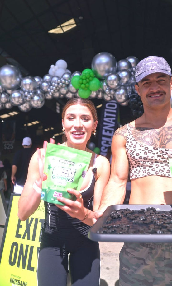 Shoppers holding Greens Gummies at a Muscle Nation tasting event